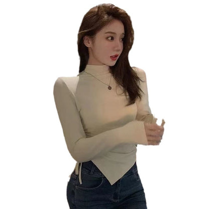 col roulé, manches longues, cordon de serrage et volants dans le bas