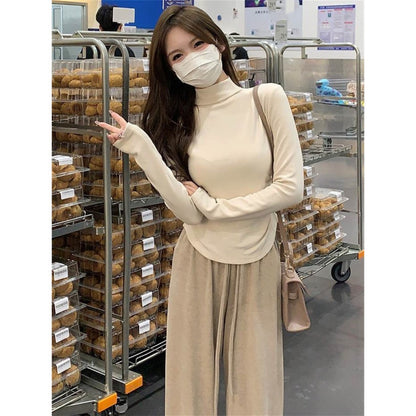 col roulé, manches longues, cordon de serrage et volants dans le bas